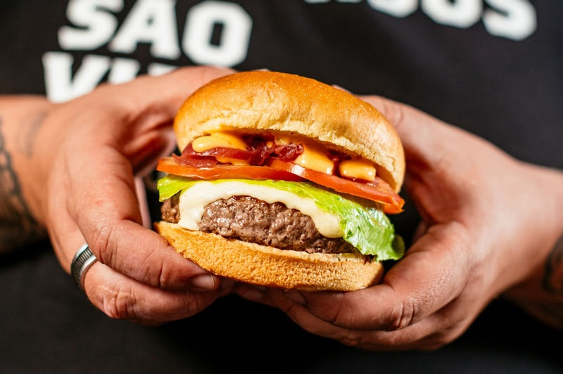 Saiba quais são os 7 erros mais comuns ao preparar um hambúrguer e como evitá-los Para quem gosta de preparar hambúrguer em casa e quer chegar mais perto do resultado de uma hamburgueria, alguns detalhes fazem toda a diferença. Do blend escolhido à montagem do sanduíche, decisões que parecem pequenas e simples podem comprometer o sabor, a textura e, principalmente, a suculência da carne. Pensando nisso, o chef Thomas Troisgros, dono do Grupo T.T. Burger, com marcas como T.T. Burger, Três Gordos, Marola Sanduicheria e Tom Ticken, comentou alguns dos erros mais comuns no preparo do hambúrguer em casa e explica como evitá-los. Afinal, mais do que escolher uma boa carne, é preciso atenção a cada etapa para garantir um burger equilibrado e saboroso. Confira abaixo: 1. Blend com pouca gordura A gordura é uma das grandes responsáveis pelo sabor e pela suculência do hambúrguer. Por isso,
